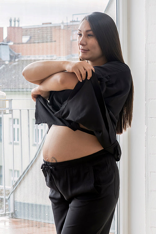 Chica embarazada con blusa y pantalon largo negros en viscosa de Forever 2