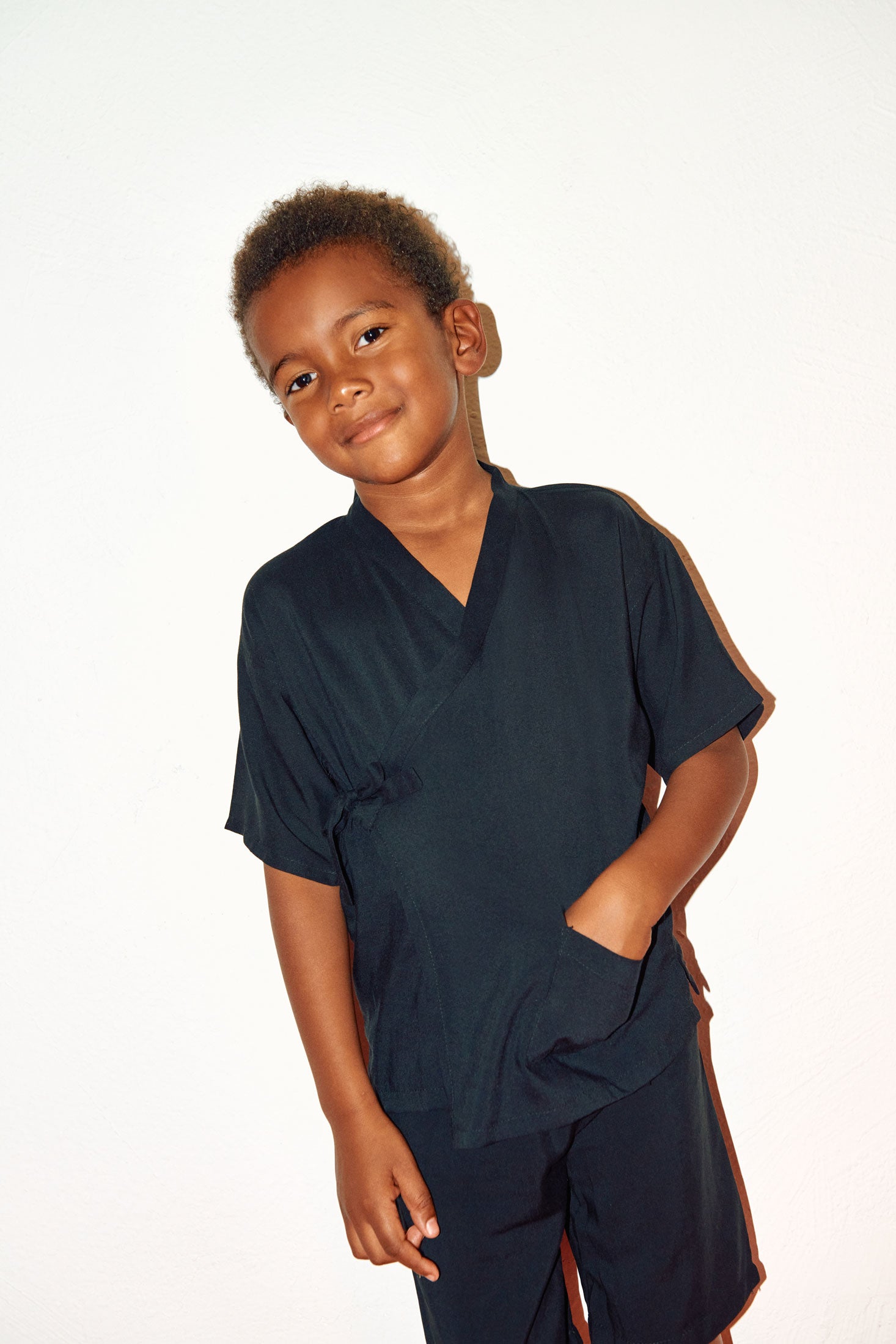 niño sonriendo con camisa negra y pantalón negro de visvosa de Forever 2
