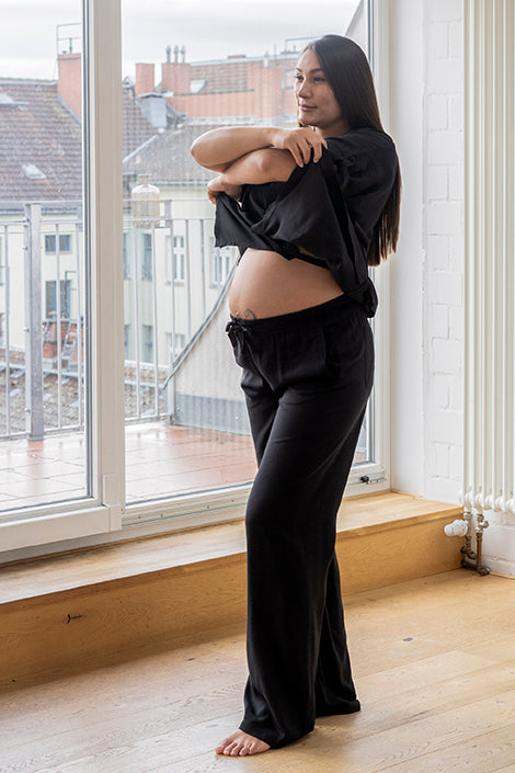 mujer embarazada con blusa y pantalón negros de viscosa Forever 2