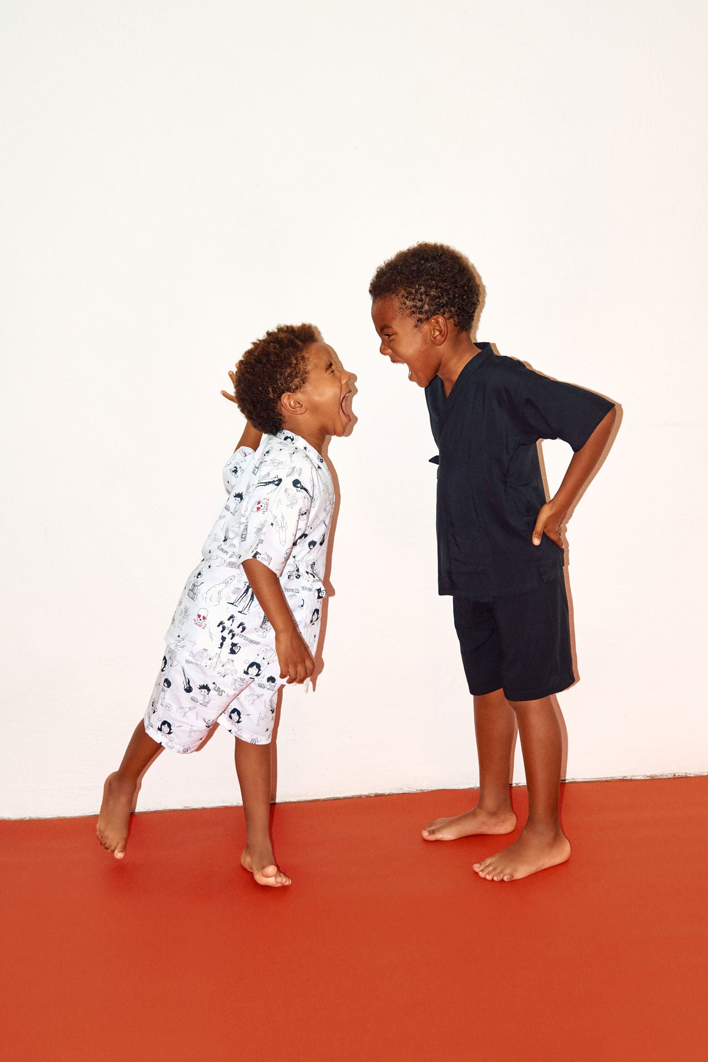 dos niños gritando cara a cara, uno con conjunto negro de viscosa y el otro con conjunto de algodón estampado de Forever 2